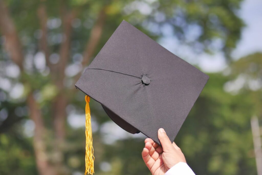 Hand som håller i studentmössa